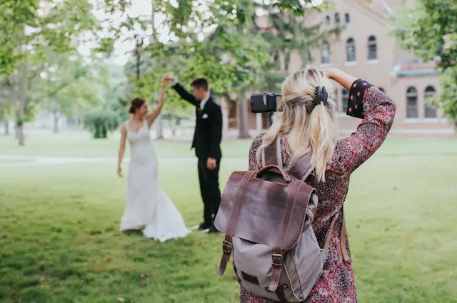 woman taking pictures of wedding couples