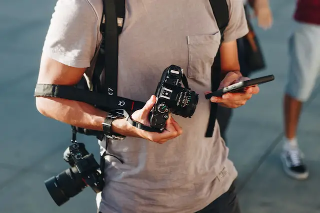 man holding two dslr camera